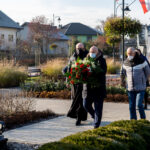 Wójt gminy Teresin Marek Olechowski, wiceprzewodniczący rady Lech Kaźmierczak i proboszcz Mariusz Książek składają kwiaty przy Pomniku 20 Rozstrzelanych