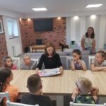 Aleksandra Starus prezentuje dzieciom kiążkę obrazkową