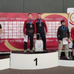 Eduard Grigorev i trener Sławomir Rogoziński na najwyższym stopniu podium kategorii wagowej do 65 kg